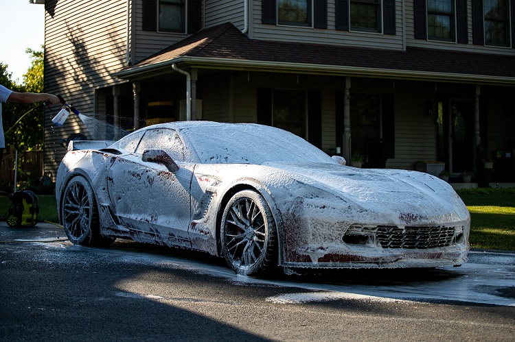 Royal Scrubs foaming a Corvette at sunset in a driveway